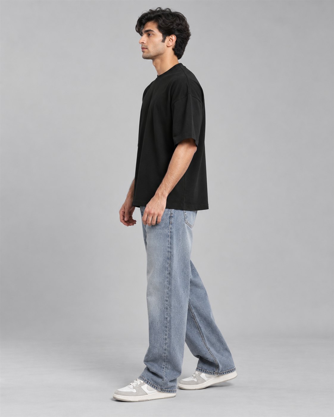 Men wearing a black oversized T-shirt, side view